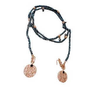Vintage layered pearl necklace with blue beads and rose gold coin pendants on white background