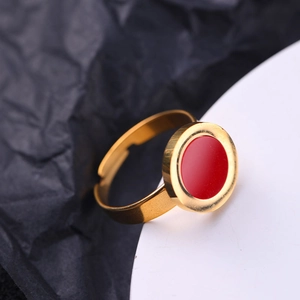 Macro view of adjustable gold ring with a minimalist flat red circular inlay detail