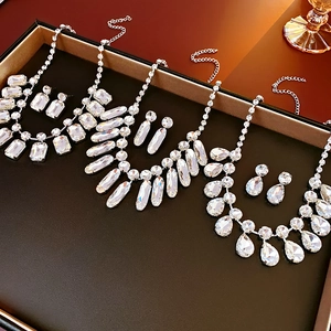 Gros plan d'ensembles collier et boucles d'oreilles argentés avec cristaux en goutte