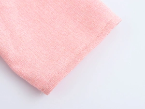 Macro view of pink textured woven fabric and cuff detail on a sweet style tweed dress