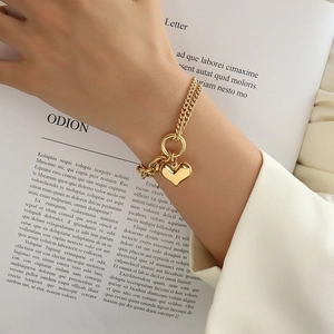 Gold double-layered stainless steel heart pendant bracelet on model with OT buckle