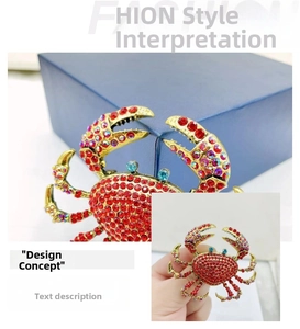 Macro view of gold alloy crab brooch with red rhinestones and blue gem eyes