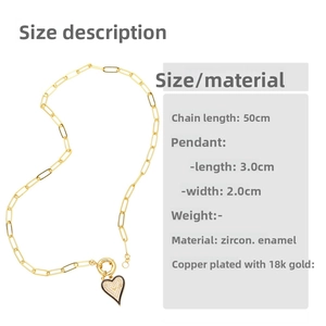 Détail macro du pendentif cœur doré avec zircons blancs et finition en émail noir brillant