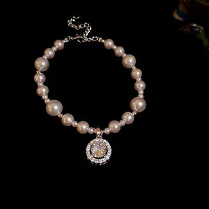 Elegant pearl bracelet with a large circular zircon pendant on a black velvet background