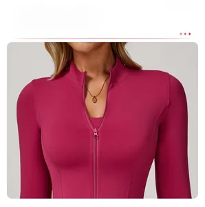 Détail du col montant et de la fermeture éclair d'une veste de yoga rose ajustée