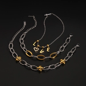 Detail of two-tone stainless steel jewelry set with heart charms and LOVE letter pendants