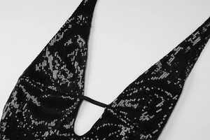 Détail du décolleté plongeant en V sur une robe à paillettes noires avec dos nu sexy