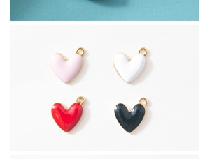 Detailed view of colorful heart-shaped alloy charms with gold edging for jewelry making