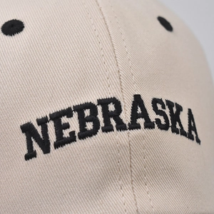 Beige cotton baseball cap with black Nebraska embroidery and premium stitched eyelets