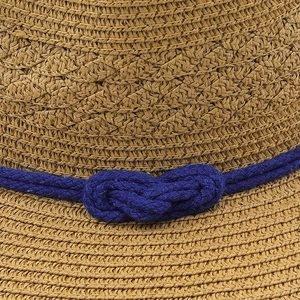 Detail of woven straw texture and navy blue rope knot on a wide brim panama sun hat