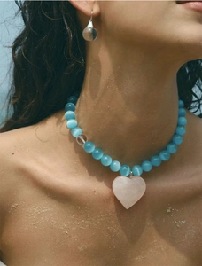 Close-up of glacier blue cat-eye beaded necklace with a pink heart stone pendant