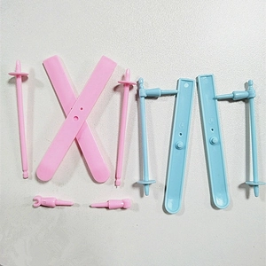 Detailed view of mini plastic ski sled accessory sets in pink and light blue colors