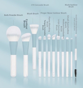 Set of 12 makeup brushes with white marble handles and blue ferrules on a blue background