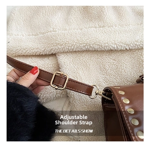 Detail of adjustable dark brown leather strap with golden metal buckle and studs