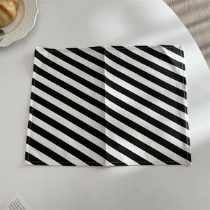 Close-up of black and white diagonal striped table mat with detailed stitching edge