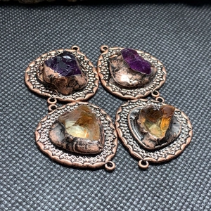 Macro-opname van ruwe amethist en citrien stenen in vintage koperen handgemaakte hangers