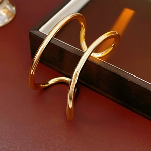 Détail d'un bracelet doré double couche irrégulier sur un plateau de présentation chic