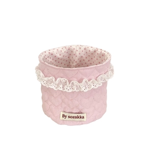 Pink quilted fabric storage basket with white lace trim and polka dot inner lining