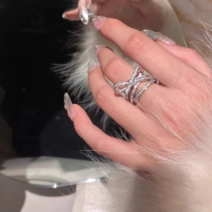 Elegant silver open ring with 3D crystal bow design worn by a female model