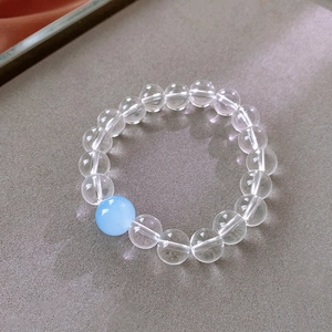 Macro shot of transparent and sky blue beaded bracelet on a professional display tray