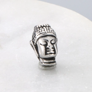 Macro shot of retro silver stainless steel Buddha head spacer bead with antique finish