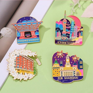 Detail of four colorful enamel Shanghai landmark pins with gold frames on a clean background