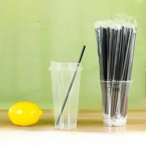 Close-up of thick black disposable straws with individual packaging for cold drink cups