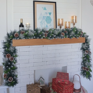 Detail of luxury flocked Christmas garland with pine cones on a fireplace mantel