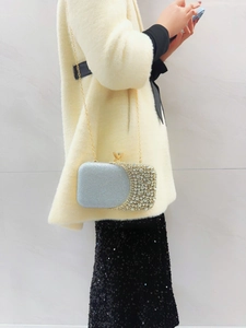 Detail of evening clutch featuring crystal rhinestones, silver glitter, and gemstone clasp