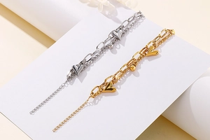 Close-up of double-layer chain bracelet with heart pendants in gold and silver finish