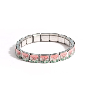 Macro detail of Italian charm bracelet with pink tulip patterns and stainless steel stamp