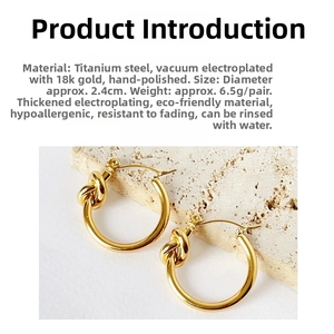 Detail of 2.4cm 18k gold plated knot hoop earrings on a stone textured background