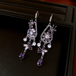 Detailed close-up of purple zircon flower earrings with sparkling drop tassels