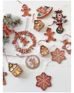 Close-up of wooden Christmas ornaments including gingerbread man and lighted house