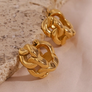 Macro detail of thick 18K gold plated chain link earrings on marble and silk