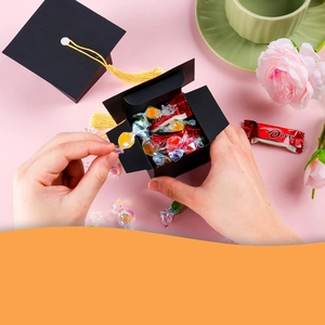 Close-up of black graduation cap gift box with gold tassel filled with assorted candies