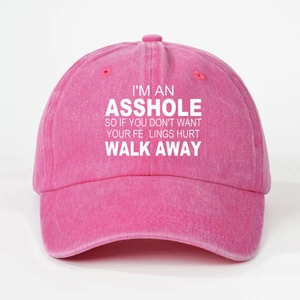 Detail of pink washed cotton baseball cap featuring bold white printed slogan lettering
