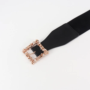 Detail of black elastic belt with rose gold square buckle and shimmering rhinestones