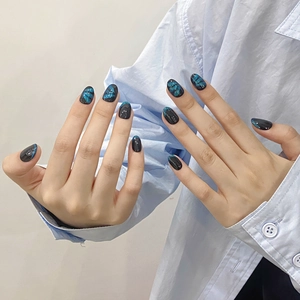Dark blue cat eye press-on nails with bow designs in long oval shape for women