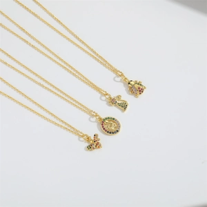 Close-up of gold necklaces with colorful zircon bee, snake, cat, and ladybug pendants