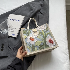 Detail of linen tote bag featuring a white floral print and natural wood button closure