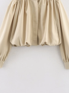 Detail of khaki cropped jacket featuring elastic ruched hem and premium woven texture