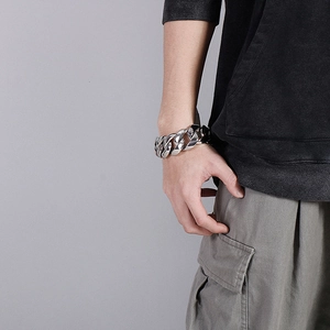 Detail of silver chunky steel chain bracelet on wrist showing punk style and heavy links