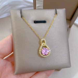 Detailed close-up of a pink round gemstone teardrop pendant with micro-pave crystals