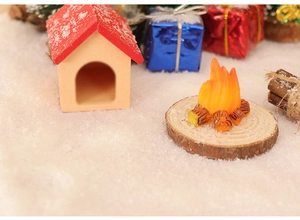 Detailed macro view of a miniature dollhouse campfire on wood base with faux snow decor