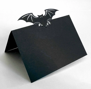 Detail of a black cardstock Halloween place card featuring a folded bat-shaped silhouette