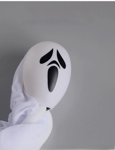 Detail of white Halloween ghost pendant with black screaming face print on fabric
