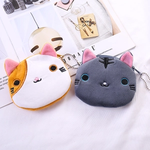 Detailed view of plush cat coin purses with embroidery and metal keychains on white fabric