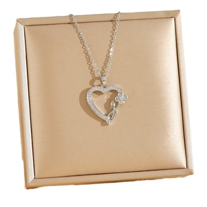 Rose heart pendant necklace in titanium steel with zircon inlay on a gold jewelry box