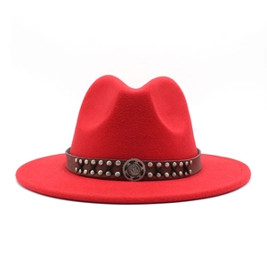 Detailed view of red wool fedora with studded leather band and vintage metal buckle